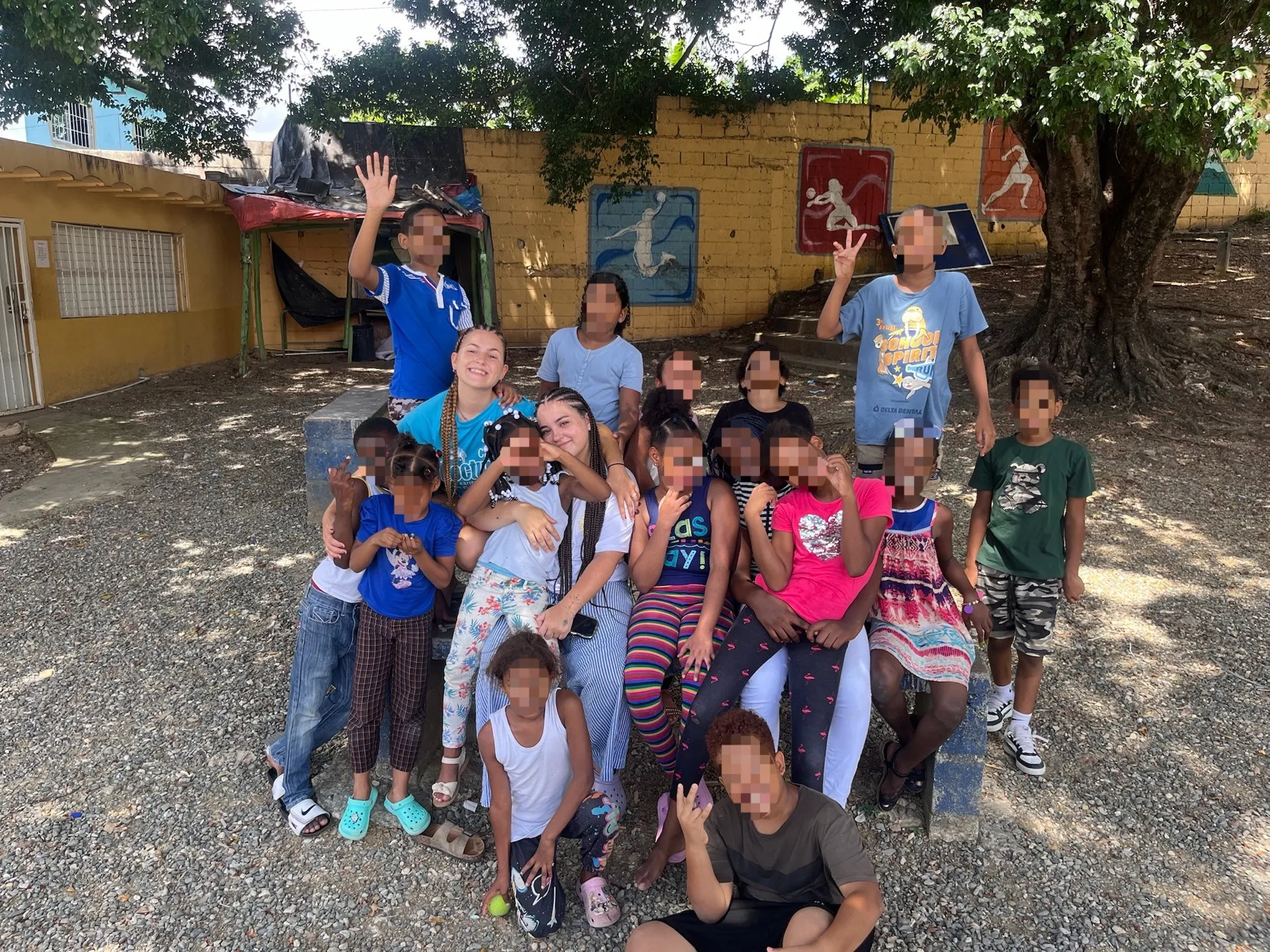 Voluntarias de Pequeñas Raíces Libres rodeadas de niños y niñas en el barrio de Guaricano, Santo Domingo